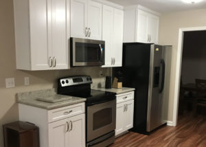 A renovated kitchen with hardwood floors and stainless steel appliances.